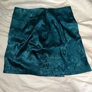 Dark green floral print a-line mini skirt. It has a slit on the side.